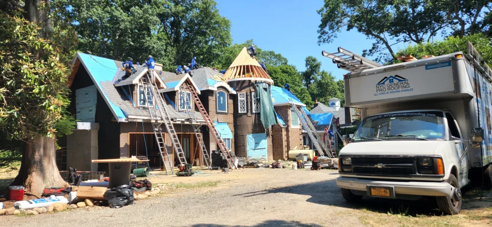 a group of workers on ladders on a house