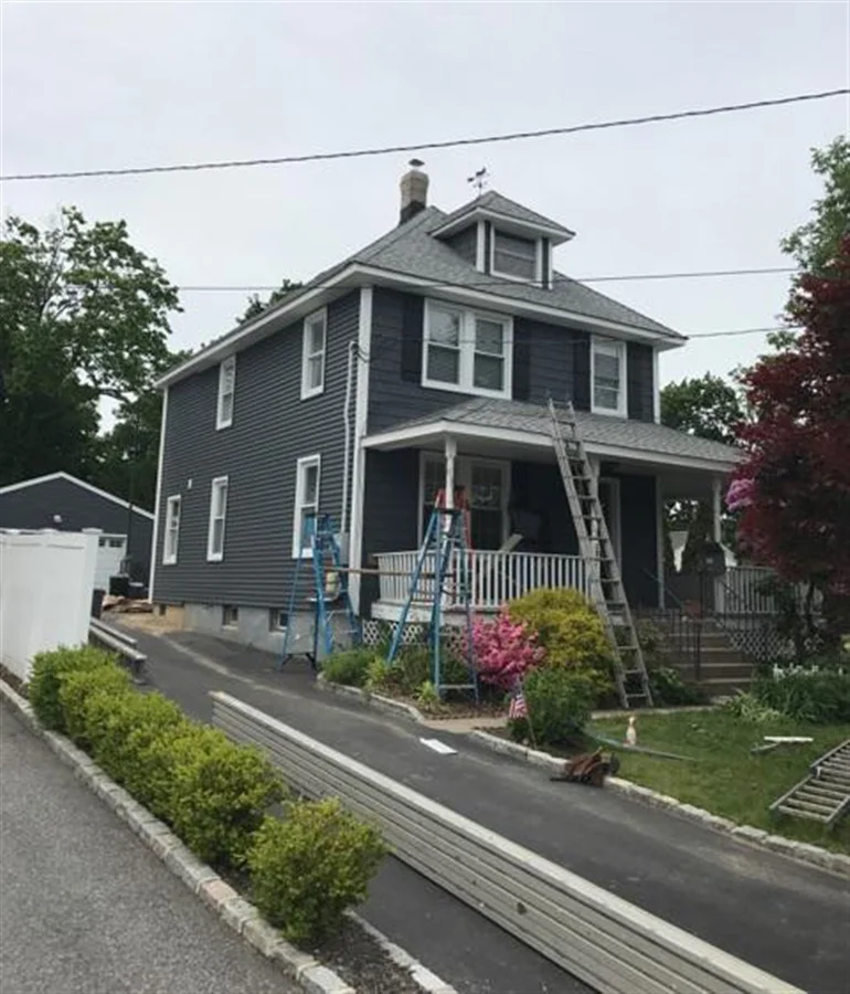 a house with ladders and a white fence